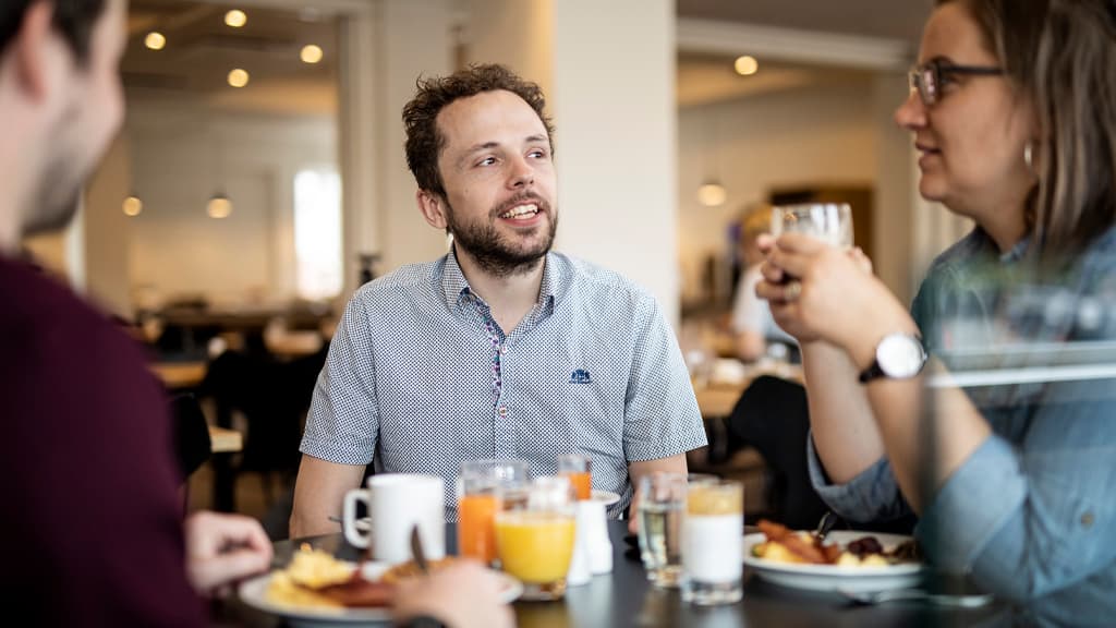 Kompas Hotel Morgenmad, gruppe snakker socialt