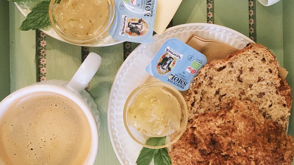 Boller med smør og kaffe på grønt bord