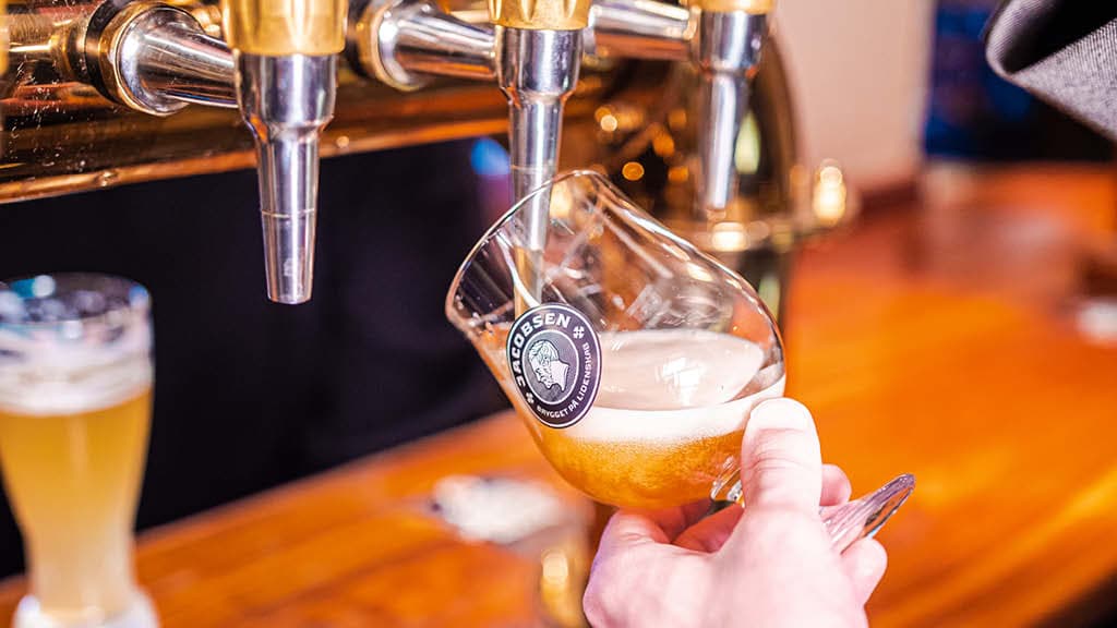 Hånd skænker fadøl op i glas